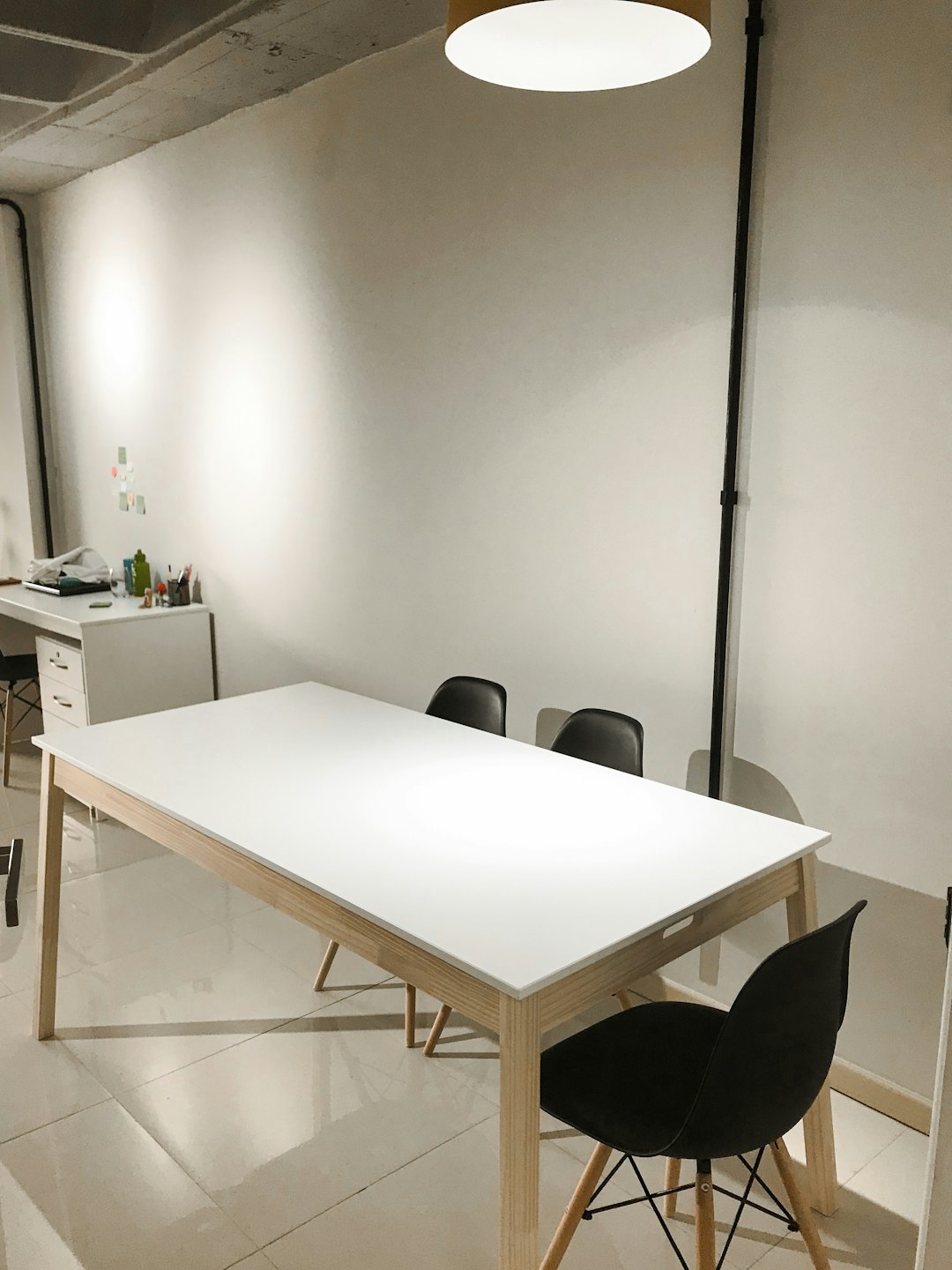 Modernt mötesrum med vitt bord och svarta stolar.